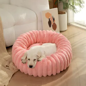 Lit douillet et rose en peluche pour animaux avec un petit chien qui dort paisiblement