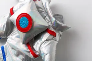 Macro detail of metallic silver pet astronaut space suit with red and blue accents