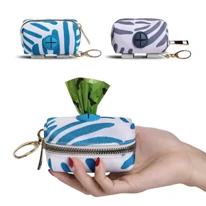 Portable canvas dog poop bag dispenser shown in hand with blue zebra stripe pattern
