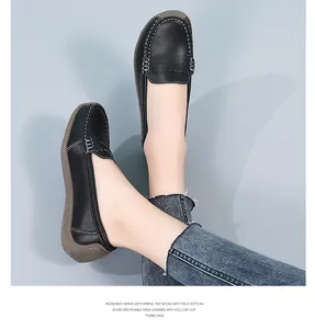 Close-up of black leather loafers on feet with white stitching and textured sole