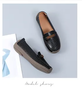Bovenaanzicht van comfortabele zwarte leren loafers met delicate geperforeerde bloemen.