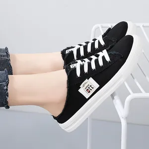 Stylish black canvas slip-on mules for women featuring frayed edges and white soles