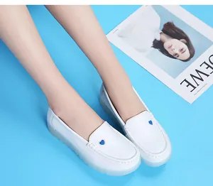 Détail de chaussures d'infirmière blanches avec broderie cœur et semelle souple