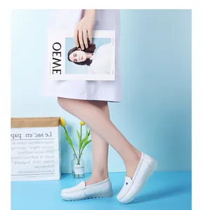 Détail de mocassins d'infirmière blancs avec cœur bleu portés par un mannequin