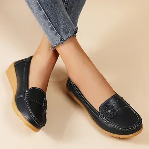 Close-up of black women's loafers with floral applique and contrast stitching