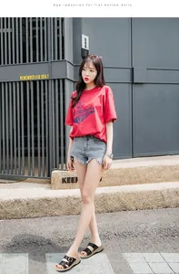 Asiatisches Model trägt schwarze Keilsandalen mit zwei Riemen und Schnallen in der Stadt.