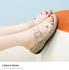 Nahaufnahme von beigen Leder-Keilsandalen für Damen mit goldener Schnalle und weicher Sohle