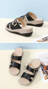 Detailansicht schwarzer Keilsandalen mit Metallschnalle und weicher Plateausohle