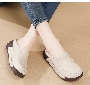Détail de mules à plateforme beiges avec tige en cuir perforé respirant.