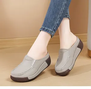 Gros plan de mules à plateforme gris clair pour femme avec dessus en cuir perforé