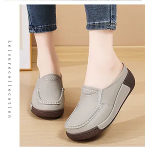 Vue détaillée de mules compensées grises pour femmes avec coutures blanches sur le pied