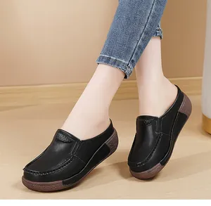 Gros plan de mules confortables en cuir noir pour femmes avec semelle plateforme marron
