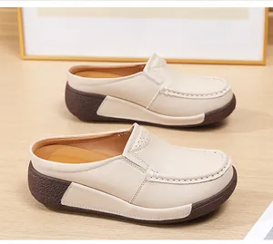 Vue détaillée de mules à plateforme crème en cuir perforé et semelles compensées brunes