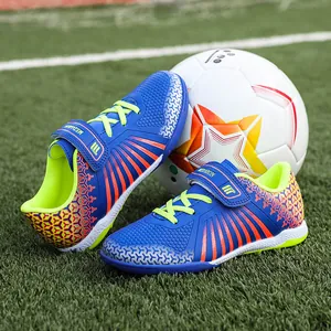 Professional junior turf soccer shoes in vibrant blue and orange color for kids training