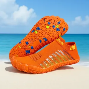 Detail van de antislipzool en het mesh van de oranje waterschoenen op het strand