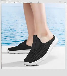 Primo piano di sabot in mesh nero traspirante da donna con morbide suole bianche