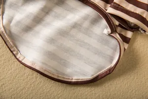Close-up detail of striped pet shirt fabric and high-quality stitching.
