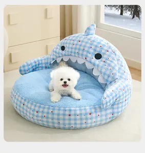 Blue shark-shaped pet bed with plush lining and a small white dog sitting inside