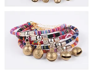 Detail of ethnic style woven pet collars with antique brass bells and metal beads