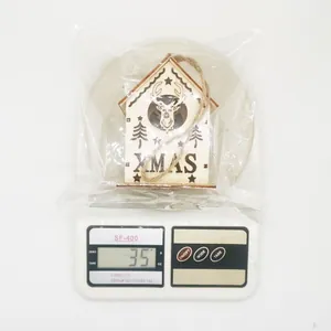 Detailed view of a small wooden Christmas house ornament weighing 35g on a digital scale
