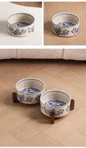 Detailed view of blue and white ceramic pet bowls on a rustic acacia wood stand
