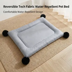 Reversible water-repellent pet mat with black pompoms for small to medium dogs and cats.