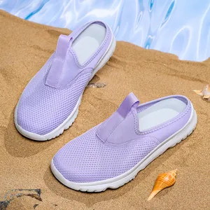 Ciabatte in rete viola traspirante con suola bianca morbida su una spiaggia di sabbia soleggiata