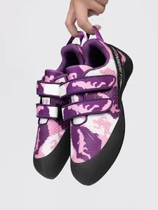 Hand-held close-up of purple camo climbing shoes with dual straps for indoor bouldering