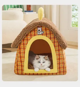 Close-up of cozy house-shaped pet bed with plaid pattern and white cat inside