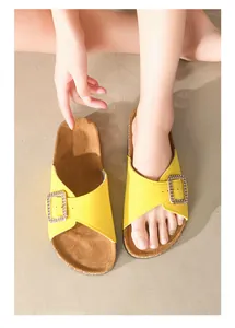 Stijlvolle gele slippers met gesp en comfortabel kurken voetbed gedragen aan voeten