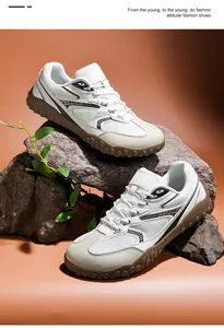 Primo piano di scarpe da trekking in rete bianca con suole carrarmato marroni su rocce