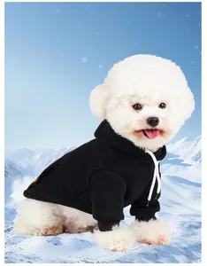 Detail view of a black warm fleece hooded pet sweater worn by a white dog in snow