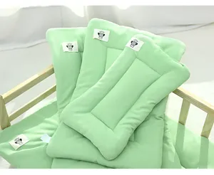 Soft light green waffle weave pet cushion for cats and dogs inside a wooden pet bed