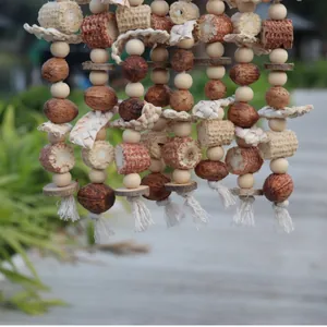 Detail van papegaaienspeelgoed met maïskolven, houten kralen en natuurlijke noten