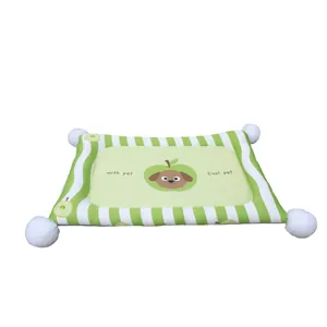 Green striped pet cooling mat with apple dog graphic and white pom-poms for dogs