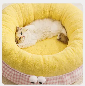 Detalle de una cama para gatos de felpa amarilla con un diseño exterior de cuadros rosas