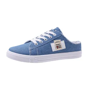 Vista lateral detallada de zapatilla mule de mezclilla azul para mujer con cordones blancos