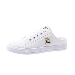Vista lateral de zapatillas mule de lona blanca para mujer con puntera redonda