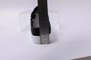 Medición de la altura del tacón de 4 cm de zapatillas bajas de lona negra para mujer.