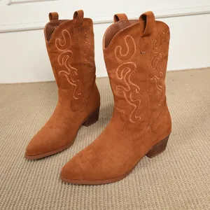 Close-up of retro brown suede mid-calf cowboy boots with elegant embroidery