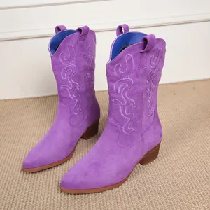 Detail view of purple suede mid-calf cowboy boots with intricate flame embroidery