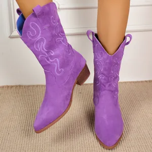 Detailed shot of purple suede western boots with intricate embroidery patterns.