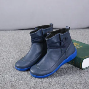 Detail view of women's blue leather ankle boots with warm faux fur lining and blue sole.