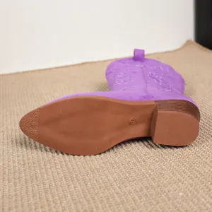 Close-up of purple embroidered western cowboy boot with rubber sole and chunky heel