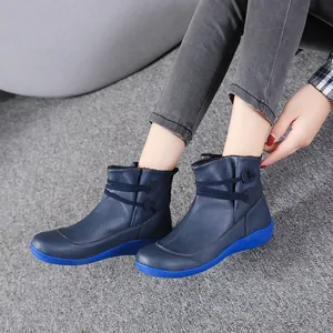 Detailed view of navy blue British style short boots with blue soles worn by a model