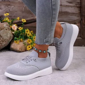 Close-up van ademende grijze mesh slip-on loafers gedragen met jeans en enkelbandje