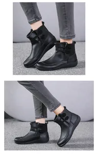 Detailed macro view of black British style leather ankle boots with decorative buttons