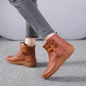 Stylish women's brown leather ankle boots with toggle button details on feet