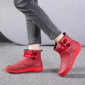 Side view detail of women's red leather ankle boots featuring unique tie-up design