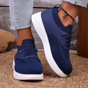 Gedetailleerde close-up van ademende blauwe gebreide sneakers met lichte witte zolen